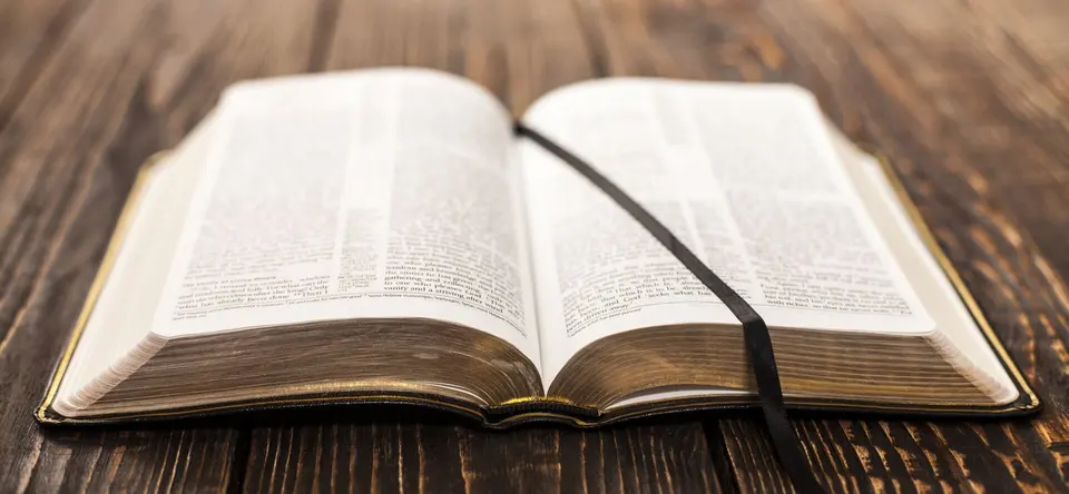 An open Bible on a wooden table